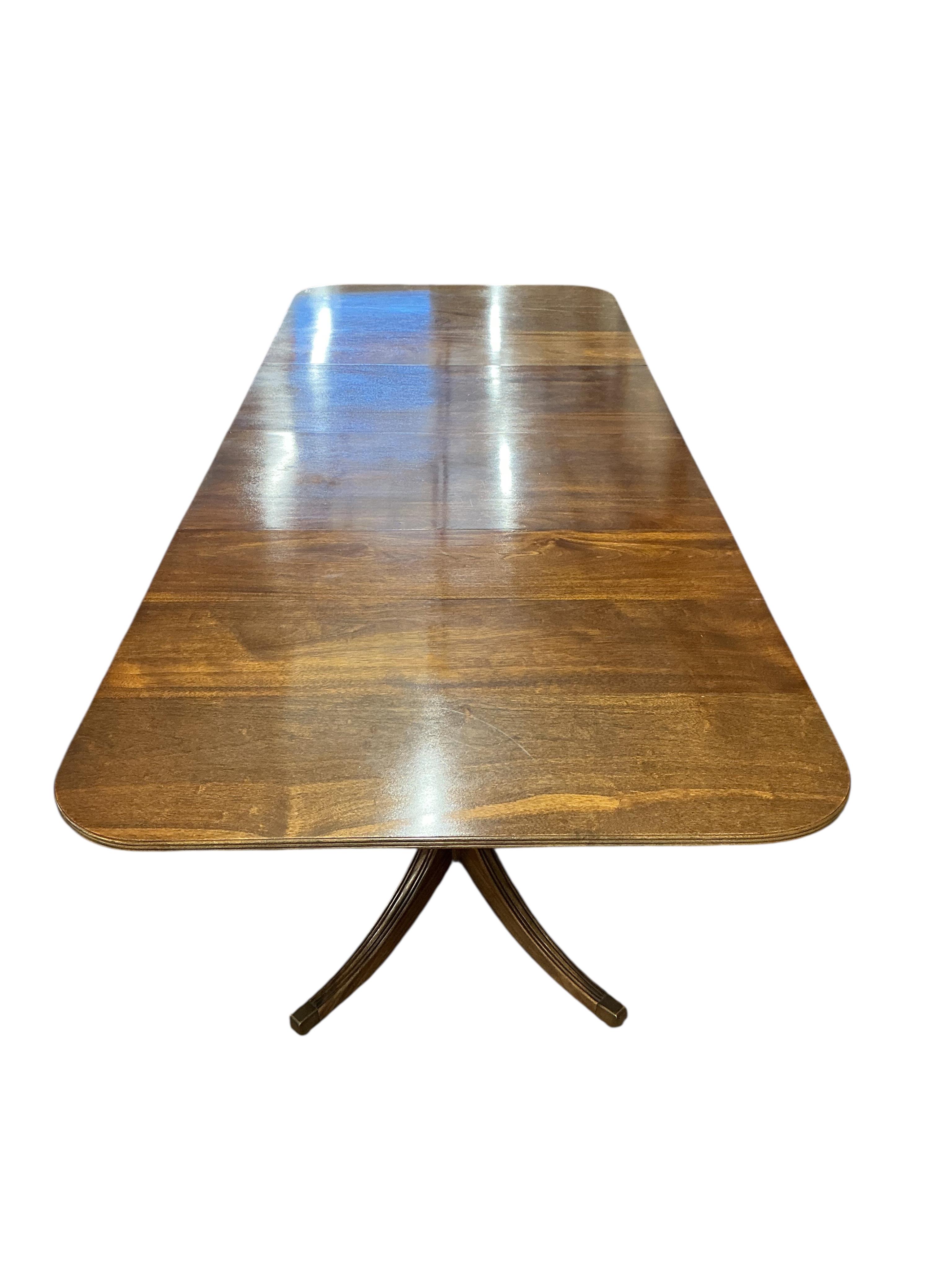 A Regency style mahogany twin pillar extending dining table, width 295cm extended, two spare leaves, depth 114cm, height 74cm